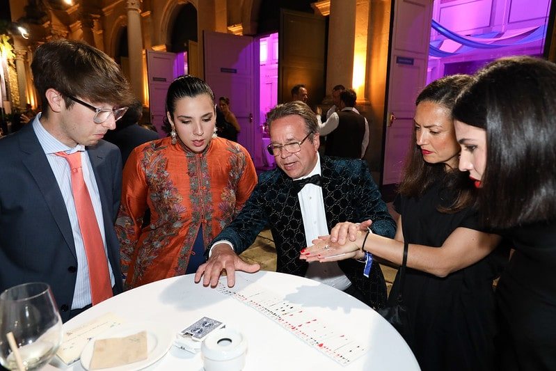 A group around a cocktail table watching cards being spread