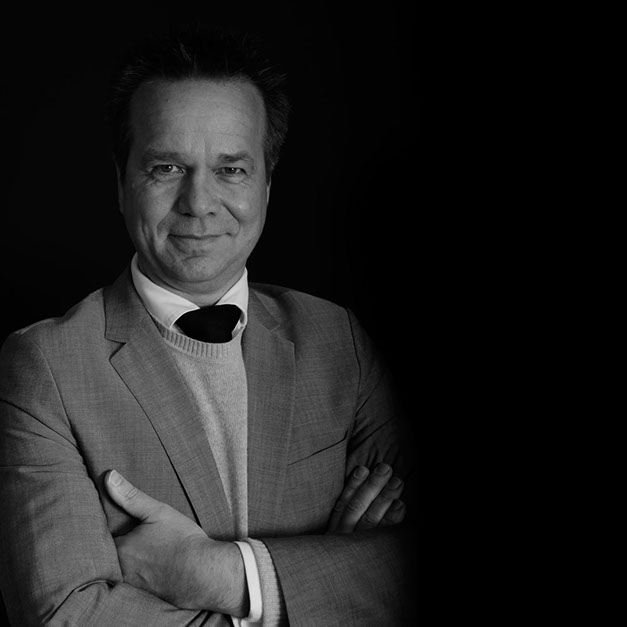 Richard Stooker photographed in black and white, arms folded